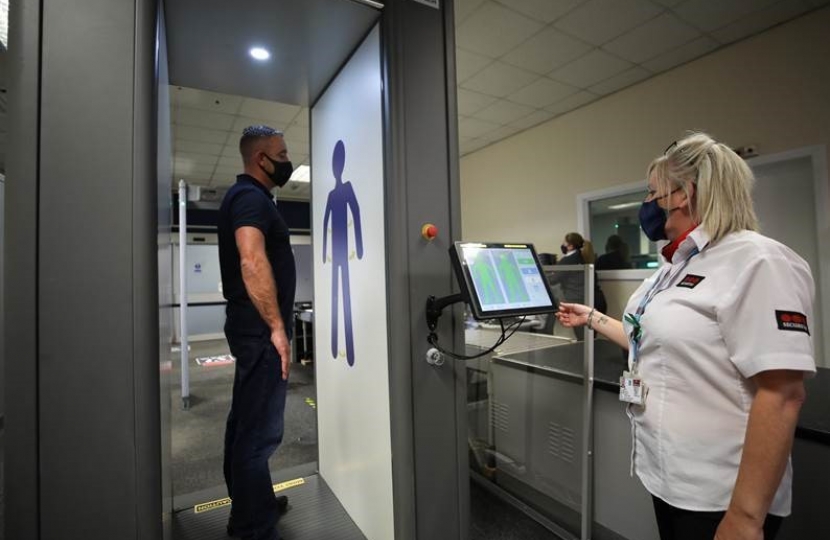 Passenger Frederick Long of Middlesbrough passes through the new security scanner at Teesside Airport with assistance of Steph Geddes of Securitas