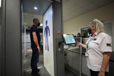 Passenger Frederick Long of Middlesbrough passes through the new security scanner at Teesside Airport with assistance of Steph Geddes of Securitas